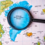NATO Meltdown: Trump Demands Greenland Magnifying glass over map of Greenland and Arctic Ocean