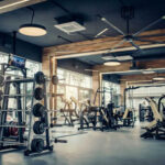 Influencer’s Brutal Belt Beatdown — Guilty Modern gym with fitness equipment and weight racks