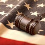 Jury Door Getaway — Accountability Missing Judge’s gavel on a folded American flag