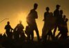 Schengen Showdown: Meloni Threatens Spain Freeze Silhouettes of people walking at sunset