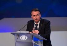 man in suit speaking at a podium