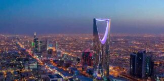 Kingdom Centre Tower illuminated over a sprawling city at dusk