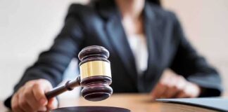 Judge's gavel striking sound block on courtroom desk