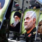 Demonstrators holding large portraits of military and political figures during a protest