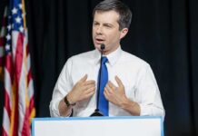 Buttigieg’s Power Play Targets SCOTUS man in white shirt and blue tie speaking at a podium