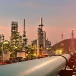 War Squeeze: U.S. Plants Push MAX Oil refinery with pipelines at sunset