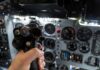 A hand holding a cockpit control device in an aircraft cockpit