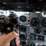 Flight Lesson Turns Deadly — Where Were The Checks? A hand holding a cockpit control device in an aircraft cockpit