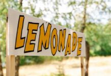 Lemonade stand sign with bold yellow letters outdoors