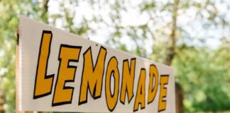 Lemonade stand sign with bold yellow letters outdoors