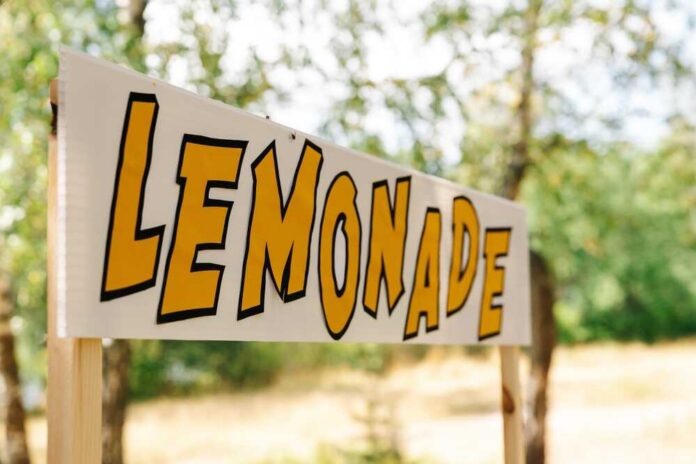 Lemonade stand sign with bold yellow letters outdoors