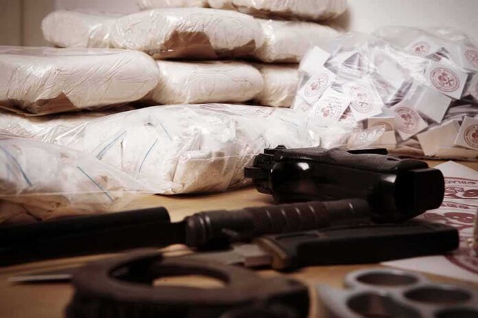 shutterstock_265783499 Piles of bagged powder with a handgun on a table