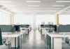 Open-plan office with rows of desks and monitors