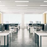 Open-plan office with rows of desks and monitors
