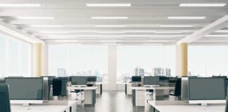 Open-plan office with rows of desks and monitors