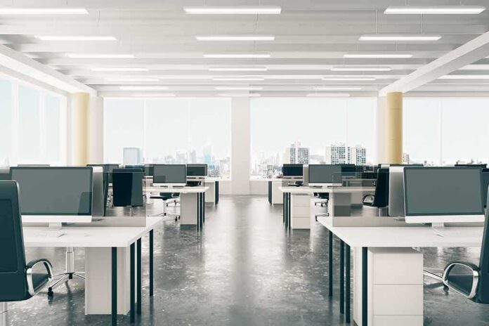 Open-plan office with rows of desks and monitors