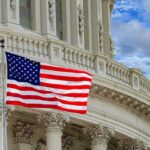 Worldwide Warning: Americans on Edge American flag waving before neoclassical government building