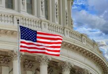 Worldwide Warning: Americans on Edge American flag waving before neoclassical government building