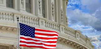 American flag waving before neoclassical government building