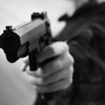 Orbeez Prank Triggers Gunpoint Takedown Close-up of a person holding a handgun in a threatening manner