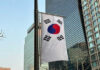 Cheap Swarms, Billion-Dollar Blind Spot South Korean flag hanging among tall buildings