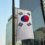 Cheap Swarms, Billion-Dollar Blind Spot South Korean flag hanging among tall buildings