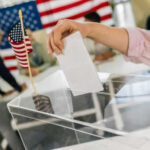 Senate Standoff Risks 2026 Chaos Hand placing ballot in box with American flag nearby
