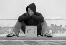 Grim NYC Math: Drugs Dominate Homeless Deaths Person sitting holding sign that says help