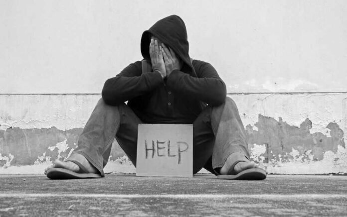 550367323 Person sitting holding sign that says help