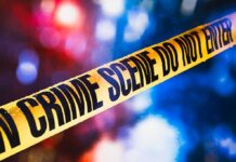 yellow crime scene tape with blurred police lights