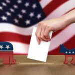 Hand casting ballot between Republican elephant and Democratic donkey