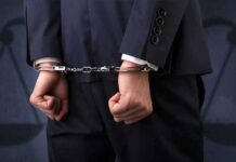 Shocking USDA Nepotism: Money Loops Back Businessperson in handcuffs with hands behind back