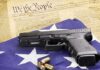 Congress Power Play: Local Bans Neutered? Handgun on American flag with ammunition and U.S. Constitution background