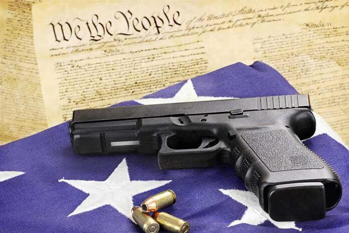 Handgun on American flag with ammunition and U.S. Constitution background