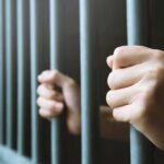 Baby Killer Demands Taxpayer Gender Perks hands gripping prison bars