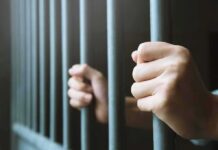 Baby Killer Demands Taxpayer Gender Perks hands gripping prison bars