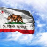 Quasi‑Socialist Insurance? Buckle Up, California California state flag waving against a blue sky