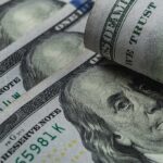 U.S. 100-dollar bills with one note rolled over Benjamin Franklin portrait
