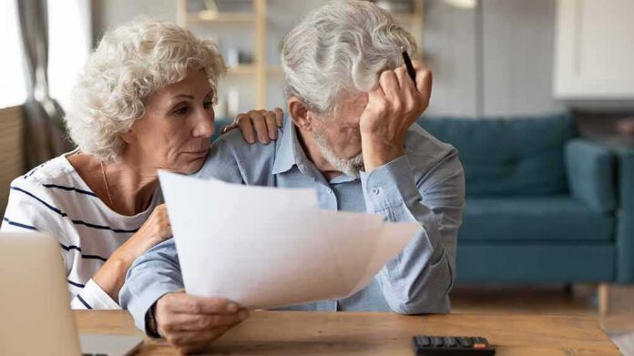 shutterstock_1667342791 Older couple reviewing bills at home