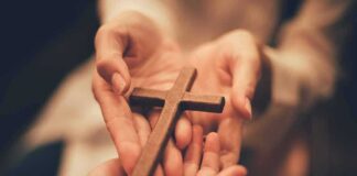 Hands holding a wooden cross