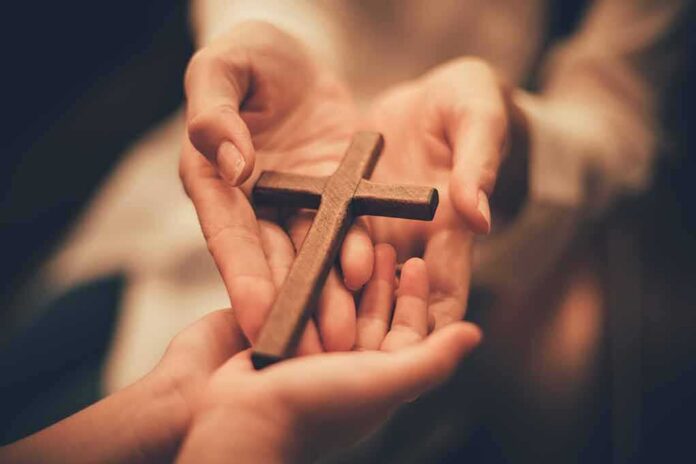 Hands holding a wooden cross