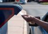 USPS Rule Ignites Pre‑Election Court Brawl Hand mailing an envelope into a blue mailbox