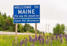 Maine Standoff Risks Capitol Shakeup Welcome to Maine roadside sign with wildflowers