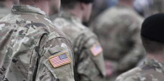 Soldiers in camouflage uniforms with U.S. flag patches