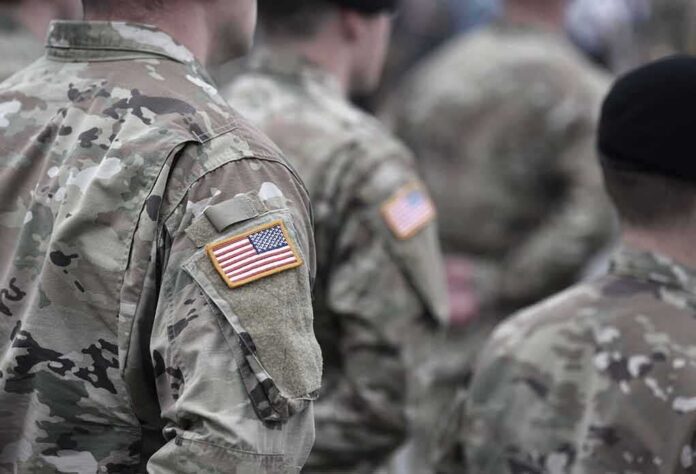 shutterstock_2038666817 Soldiers in camouflage uniforms with U.S. flag patches