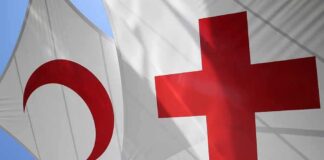 Red Cross and Red Crescent flags against blue sky
