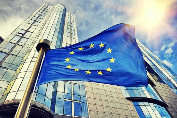 shutterstock_317833073 European Union flag waving in front of modern glass office buildings