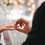 Close-up of a wedding ring being placed on a bride's finger