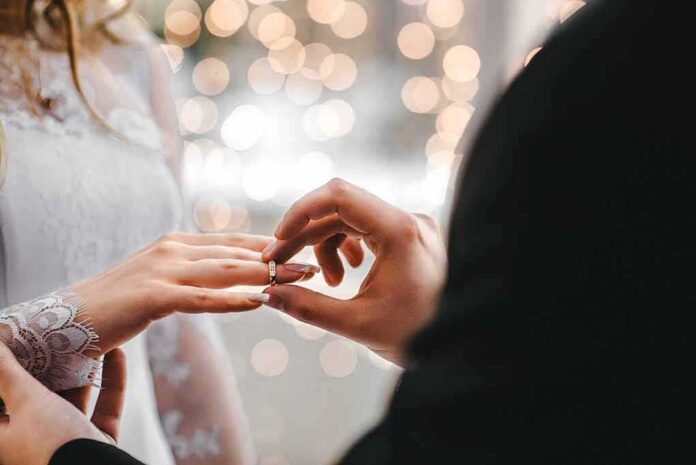 shutterstock_589431530 Close-up of a wedding ring being placed on a bride's finger