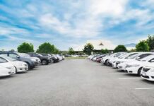 Parking lot lined with cars under a blue sky